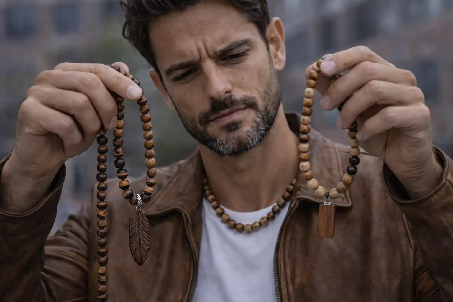Homme comparant deux colliers en bois avec perles naturelles pour choisir un modèle adapté