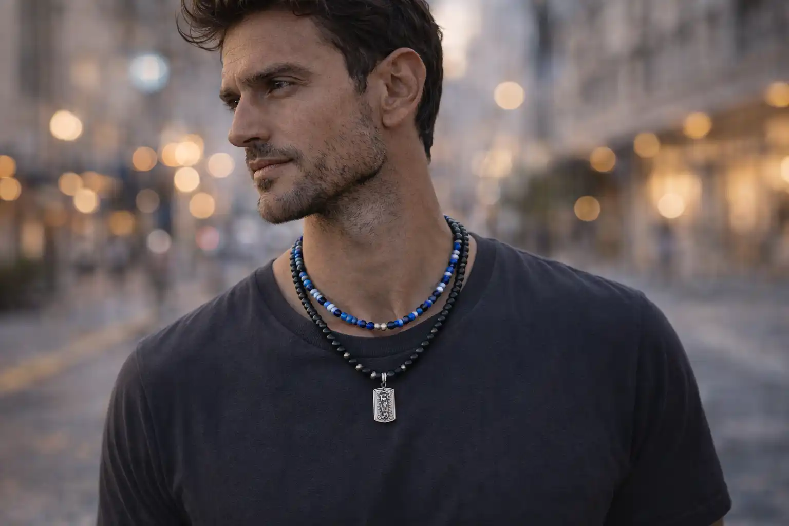 Homme portant un collier en pierre naturelle avec perles noires et bleues en milieu urbain