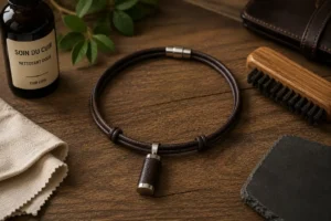 Collier en cuir pour homme posé sur table en bois avec accessoires masculins dans une ambiance chaleureuse et authentique